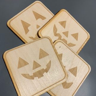 four wooden laser engraved pumpkin coasters