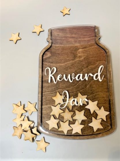 Laser cut wooden jar with clear acrylic with the word 'reward jar' in white on the front. Small laser cut starts scattered inside and around the jar.