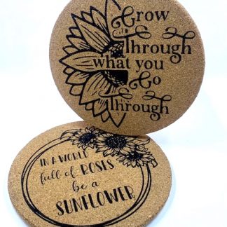 laser engraved circular cork trivets with the sayings 'Grow through what you go through' and 'In a world full of roses, be a sunflower'