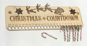 Laser engraved sign with Christmas countdown numbers on it. With little holes to put candy canes threw as your countdown markers. 