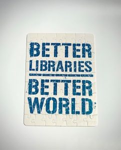 Cardboard puzzle with sublation image on it. "Better Libraries, Better world in teal