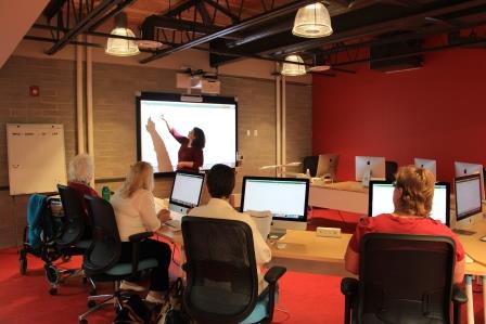 woman instructs a class in the computer lab